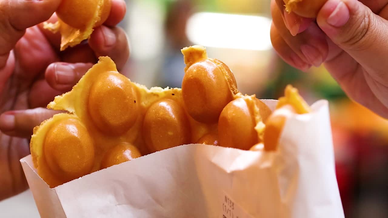 바쁜 거리에서 버블 와플을 나누는 손