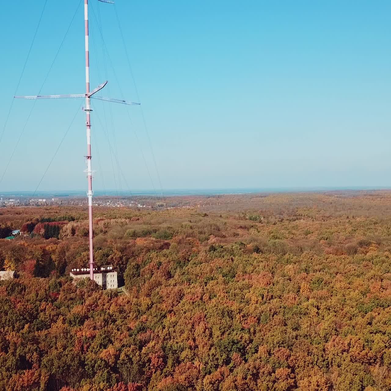 aerial view of the TV tower on the background of the forest. Camera motion up