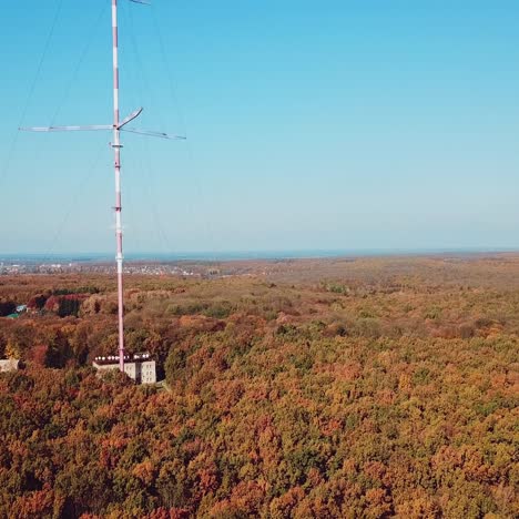 aerial view of the TV tower on the background of the forest. Camera motion up