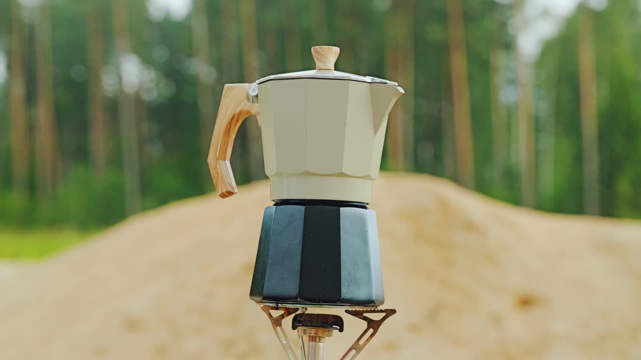 Coffee brews in classic pot on burner surrounded by calm nature in rural Latvia