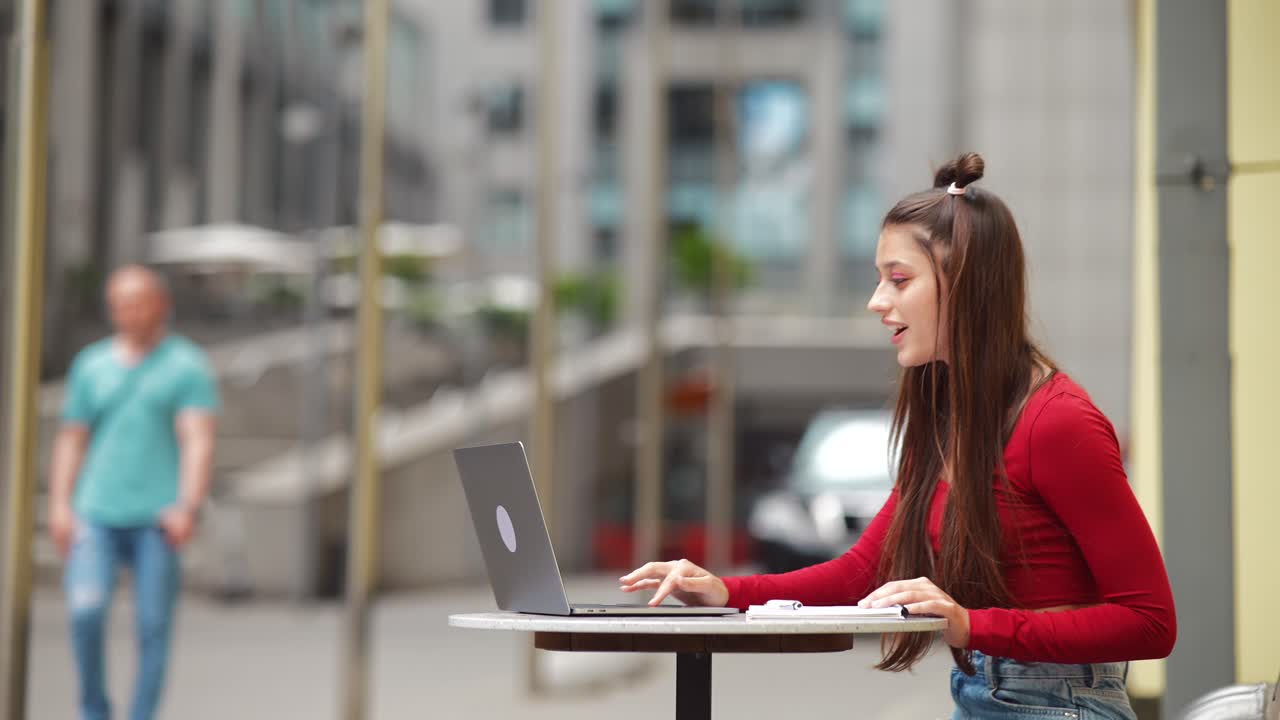 mujer joven trabajando en una computadora portátil al aire libre