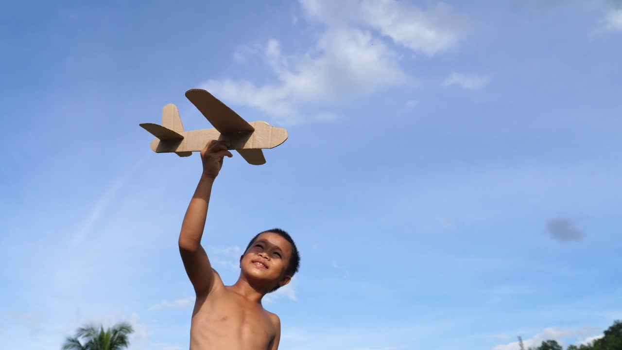 Boy Playing with a Cardboard Airplane