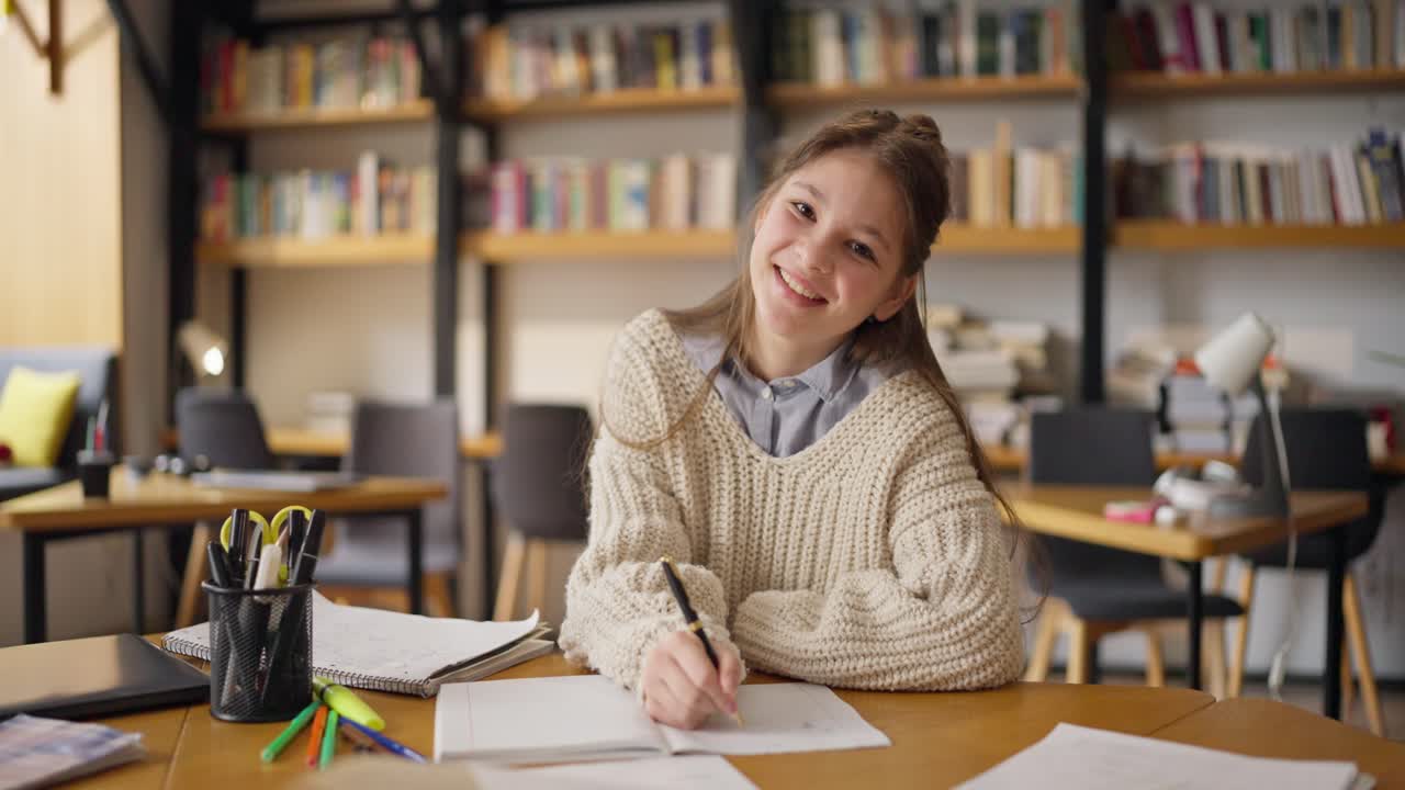 Tenåring som studerer på et bibliotek