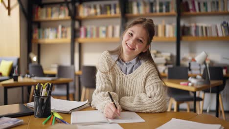 un adolescente estudiando en una biblioteca