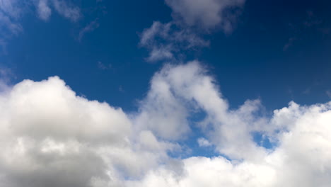 nubes blancas esponjosas moviéndose contra el cielo azul profundo