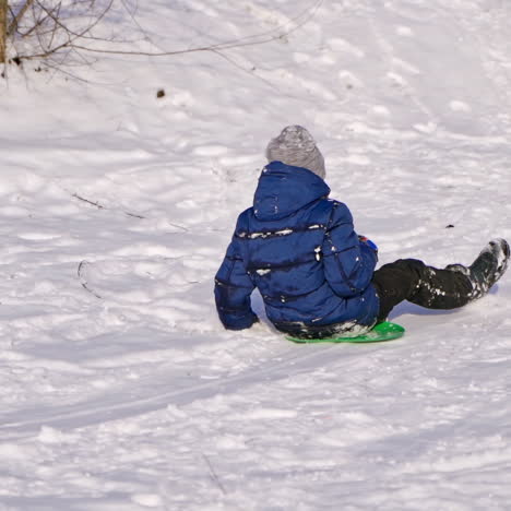 frost winter season. two children ride down a hill, winter games and fun. kids laughing, sledging down a hill. children ride down a hill, winter games and fun. slow motion.