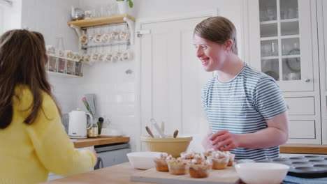 Junges-Down-Syndrom-Paar-Dekoriert-Hausgemachte-Cupcakes-Und-Tanzt-In-Der-Heimischen-Küche