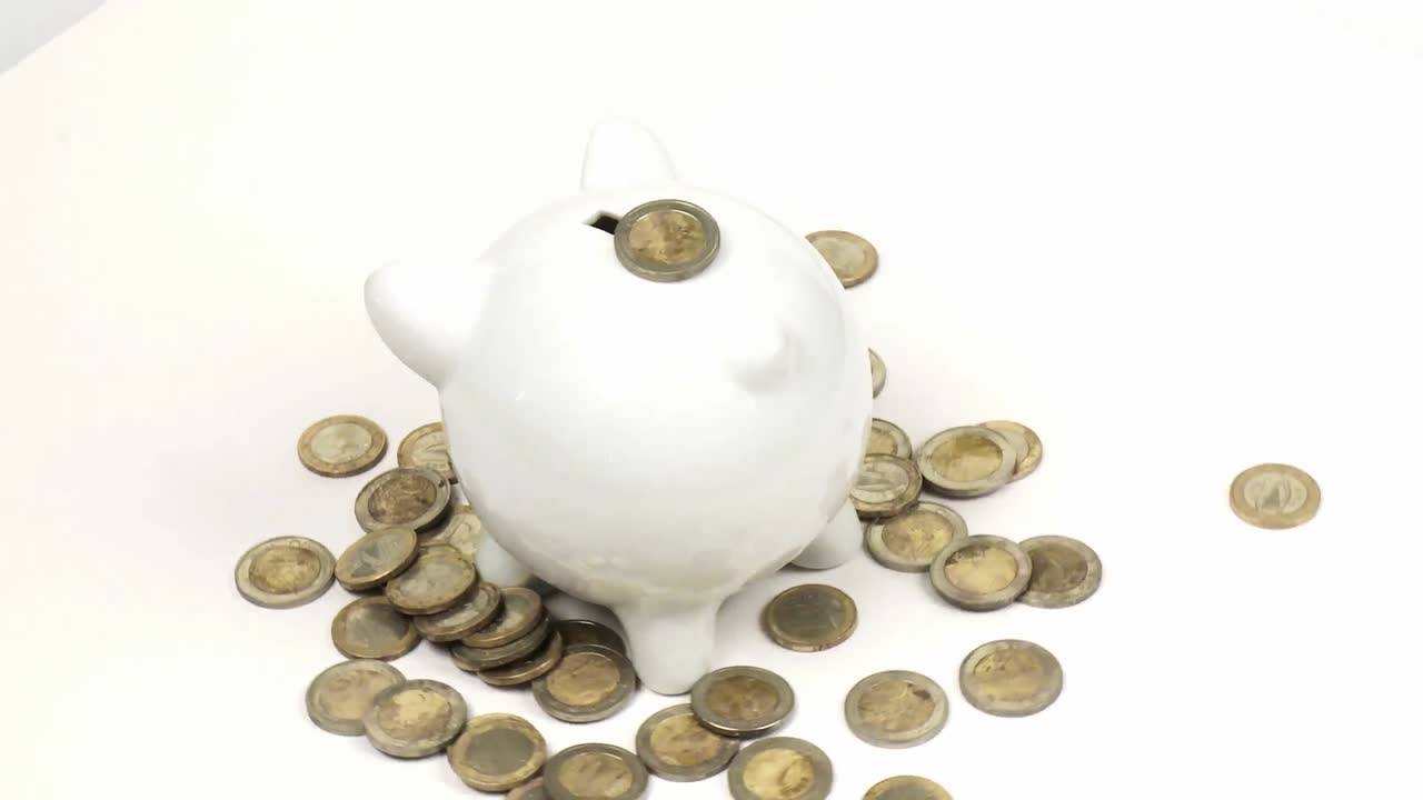 Sparschwein, das sich mit vielen Münzen dreht