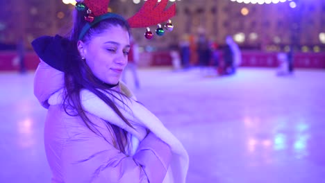 woman ice skating at night with christmas decorations