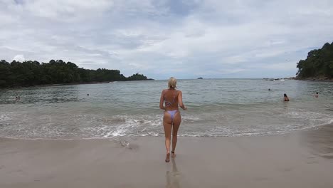 Niña-Corre-Al-Borde-Del-Agua-En-La-Playa-En-El-Parque-Manuel-Antonio,-Costa-Rica