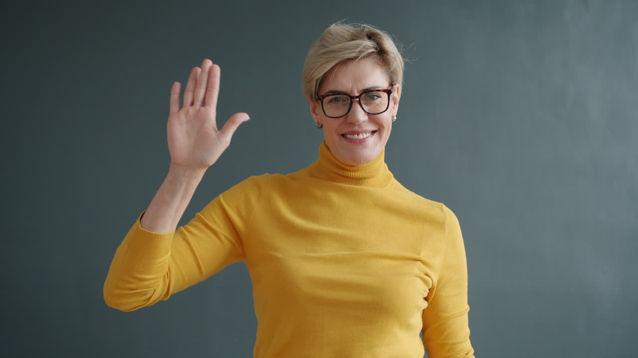 una mujer saludando.