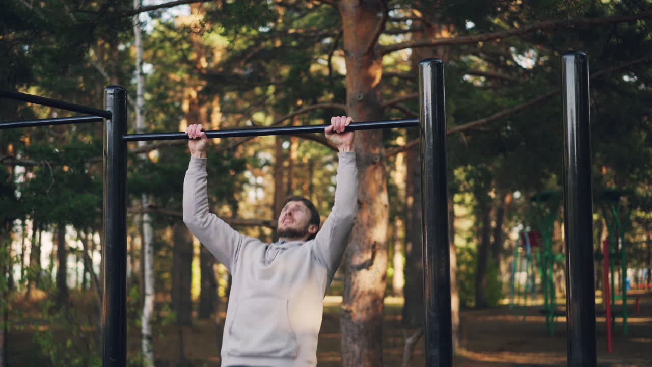 hombre haciendo pull-ups en un parque