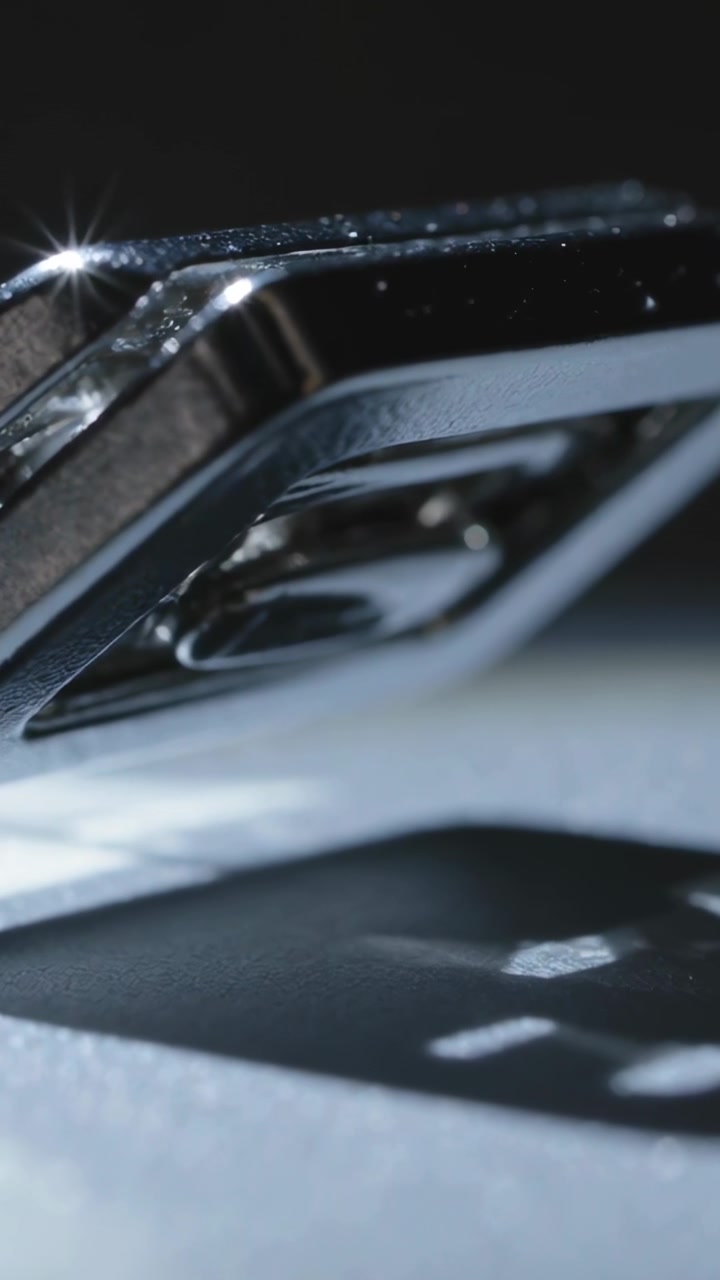 Vertical video: Catching light, chrome part tilting above base, showing dust, shadow shift for test