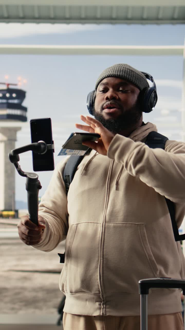 Video verticale: Viaggiatore solitario che registra un vlog nella sala d'attesa del terminal aeroportuale.