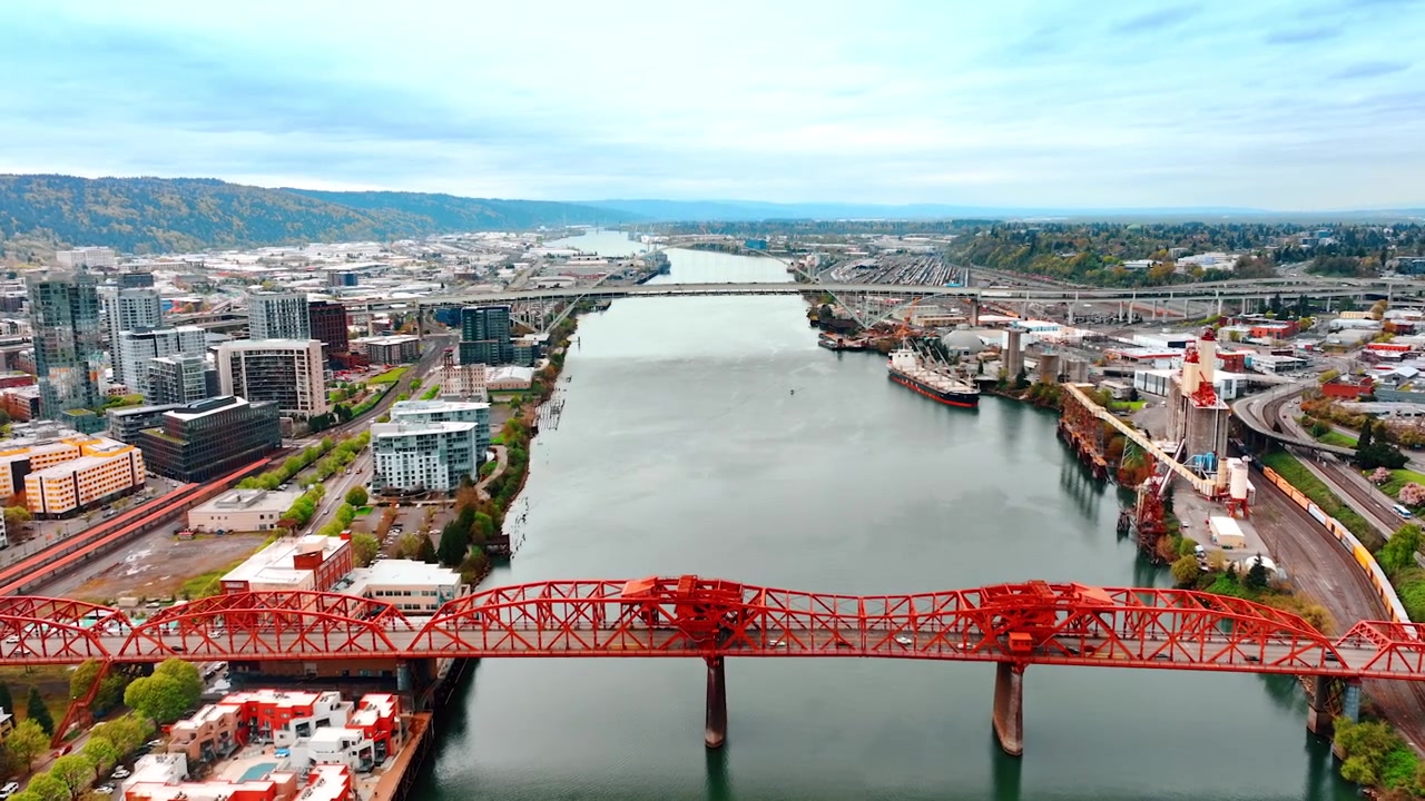 Volo sopra il fiume Willamette e i ponti su di esso a Portland, Oregon, USA. Immensa vista della città di giorno. Veduta aerea.
