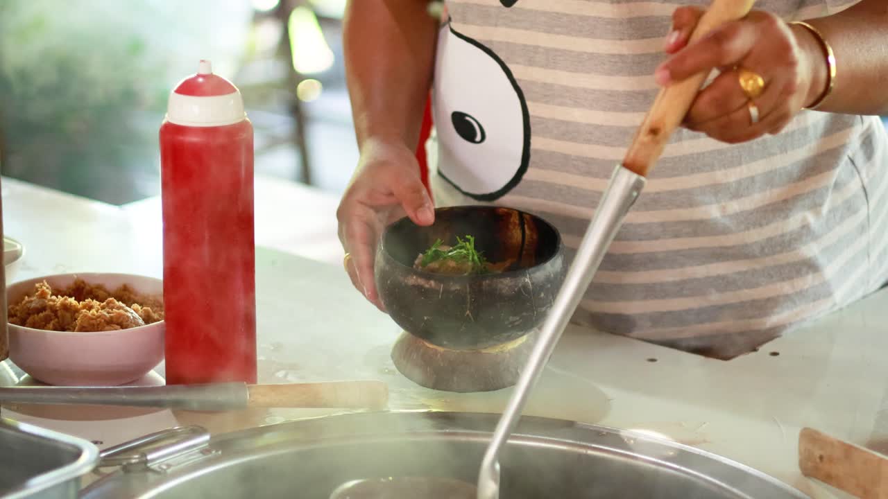 preparando un plato de fideos con carne de cerdo y cáscara de coco