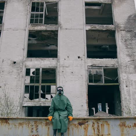 survivor after nuclear chemical incident. man in gas mask near abandoned destroyed building