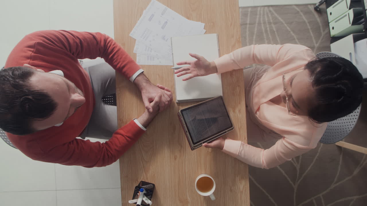 Sales Manager Discussing Working Tasks with Male Employee Top View