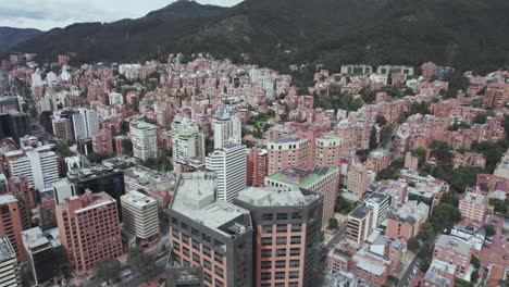 aerial view starting from the mountains wrapped in clouds, gradually zooming in to reveal houses and buildings in detail.