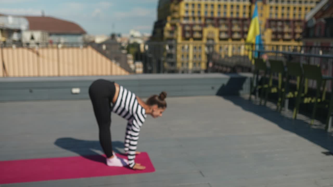 mujer practicando yoga en un techo