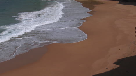 Olas-Azul-Verdoso-Se-Lavan-En-Una-Playa-De-Arena