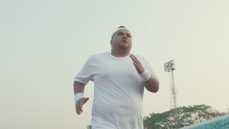 tried fat man running for exercising at stadium