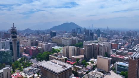 backward drone shot revealing santiago cityscape with entel tower and cerro san cristóbal in the background