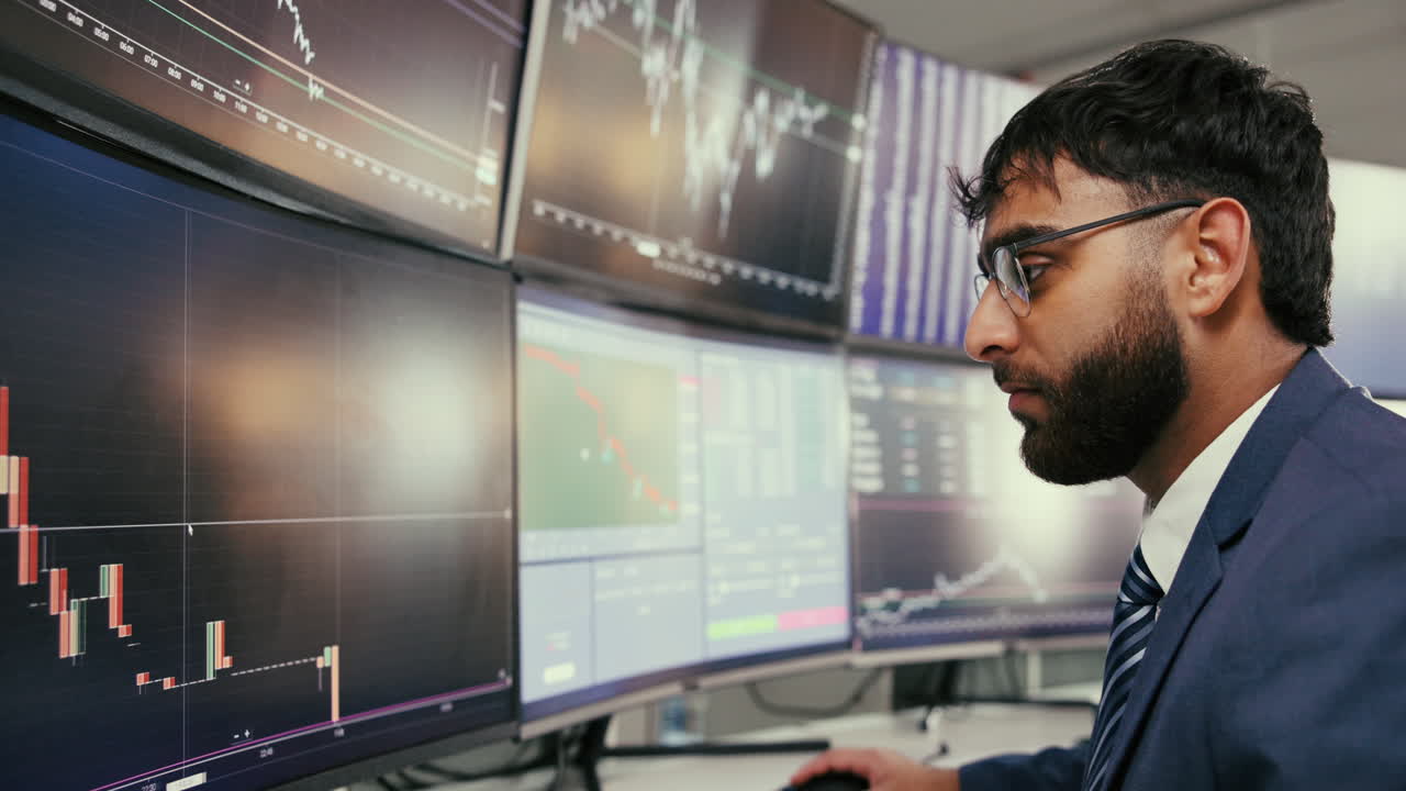Businessman Analyzing Financial Data on Multiple Screens