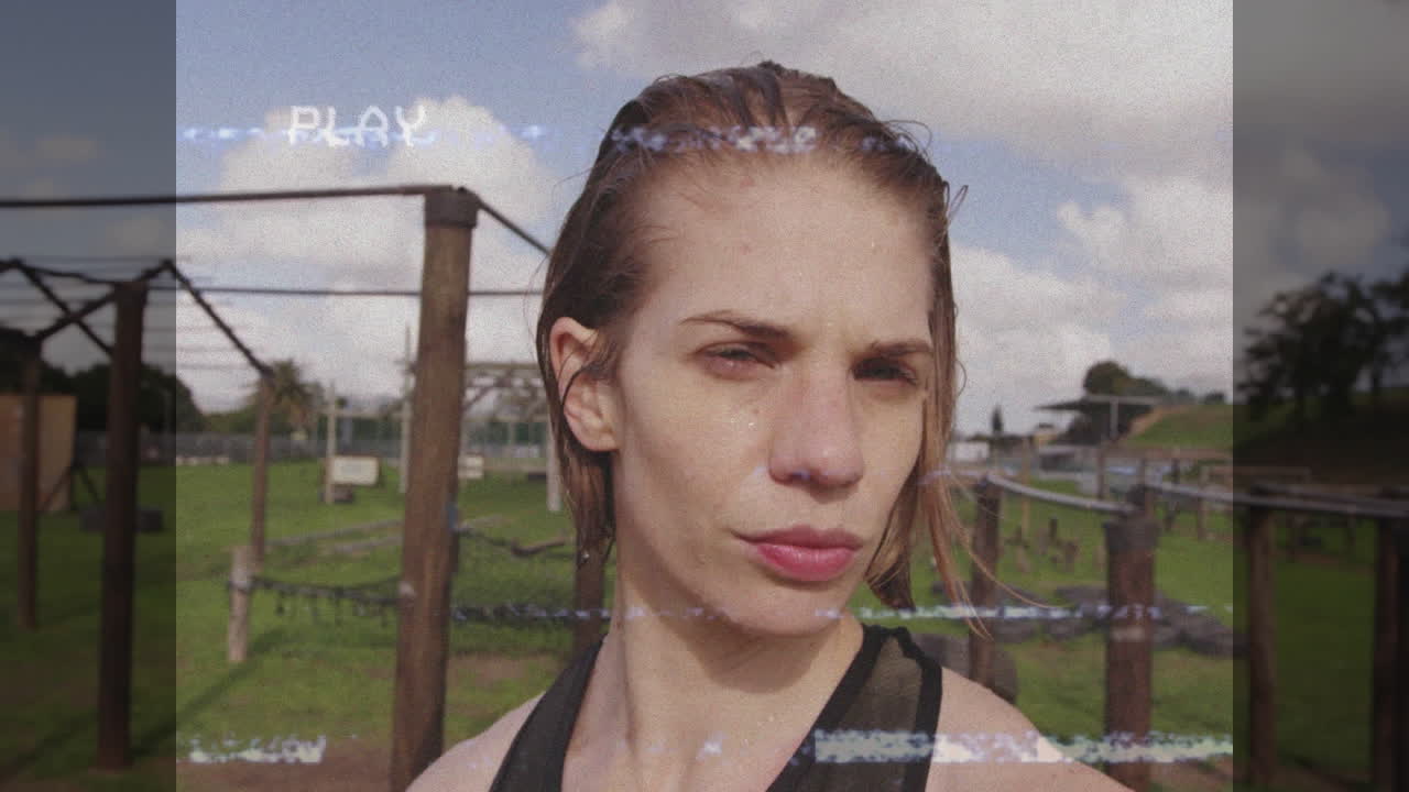 Woman tackling wooden poles, rope net and cable obstacles for fitness with VHS glitch showing PLAY