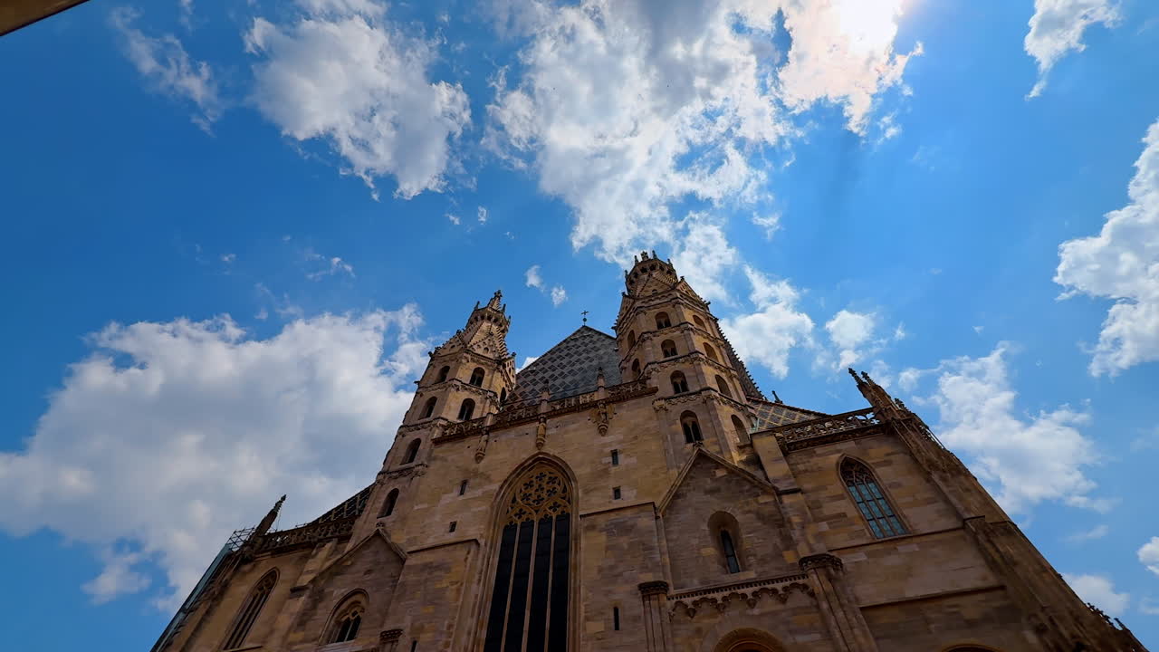 Vienna, Austria - June 9, 2025: Towers on the roof of the front façade of Saint Stephen's Cathedral. Low angle view at the historical building at the backdrop of blue sky. Vienna, Austria