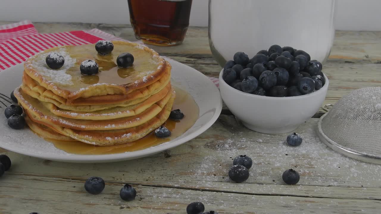 베리와 메이플 시럽과 함께 미국 버터 밀크 팬케이크의 어리 맛있는 달한 아침 식사 음식 은 시골 배경에 팬케이크는 색입니다.