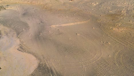 forward moving drone over vast barren sandy land on bright sunny day