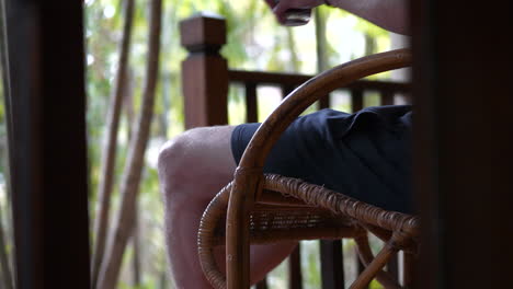 close up on hand of man with bracelet holding glass