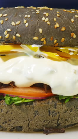 tasty brown burger prepared by a professional chef. burger prepared. fresh tasty burger with cheese and vegetables. close-up. vertical video