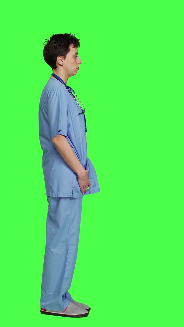 Profile Displeased nurse saying no and sighing against greenscreen backdrop
