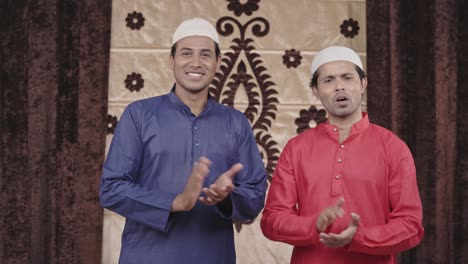 two proud muslim men clapping and encouraging someone