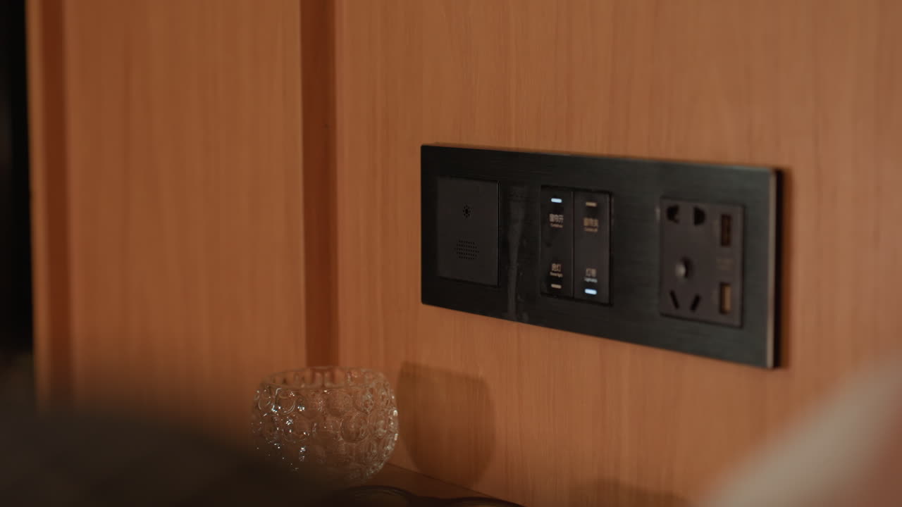 Traveler charges device in cozy hotel room at night. Relaxing late night in hotel with warm lighting and peaceful ambiance. Traveler quietly recharges device in dimly lit hotel room at night