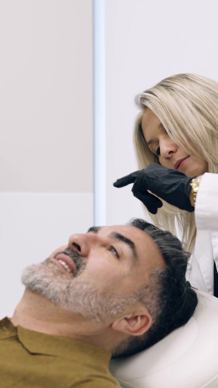 Dermatologo che esegue una procedura estetica su un uomo maturo in clinica