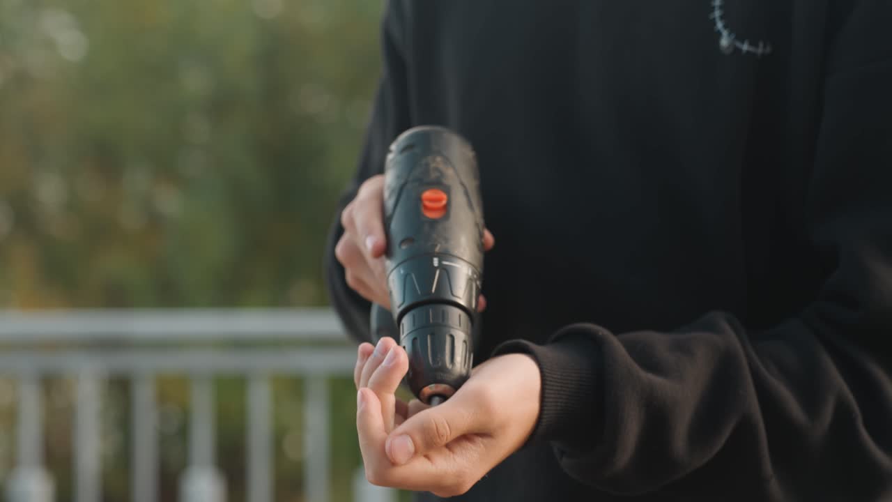 Utendørs borearbeid. Trening på riktig grep under utendørs boring. Korrekt håndtering av elektroverktøy i friluft. Lære trygge teknikker for bruk av batteridrill utendørs.