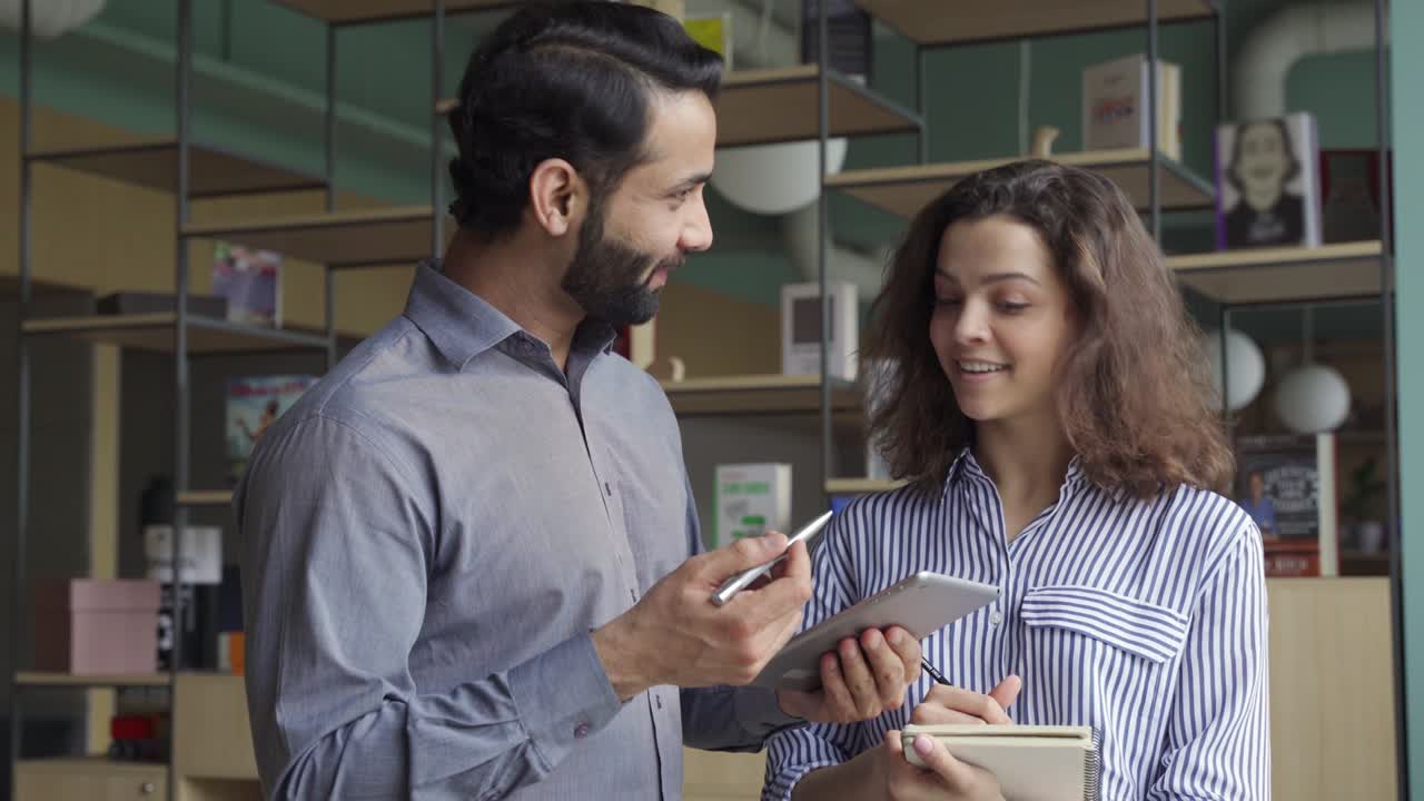 diversos compañeros de trabajo amigables hablando usando tableta digital en la oficina.