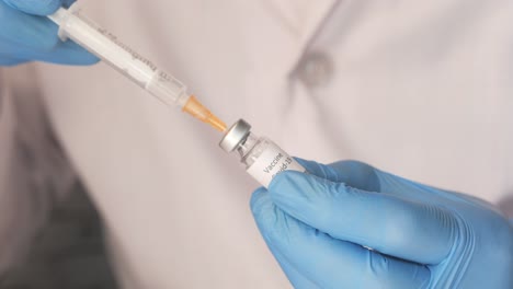 médico que está preparando una inyección de vacuna contra la covid-19