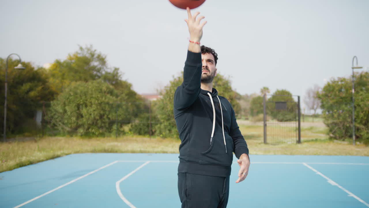 Basketball Player Does Tricks With the Ball Spinning at the Park Court