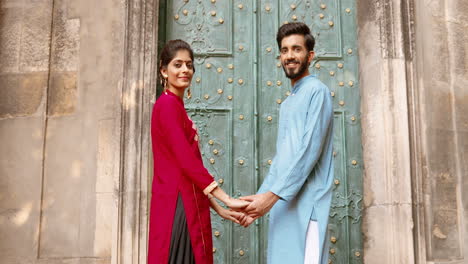 Young-Indian-couple-holding-hands-in-front-of-a-beautiful-door