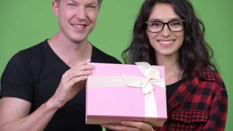 young couple holding gift box together