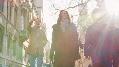 group of mature friends walking through city in fall together