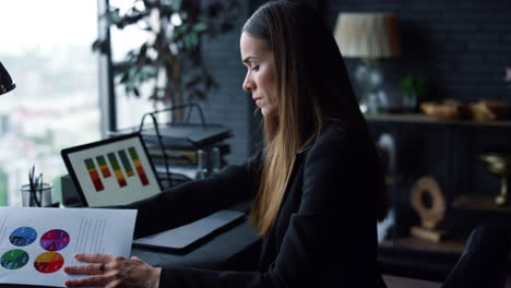 Businesswoman-working-with-papers.-Professional-looking-at-reports-on-document