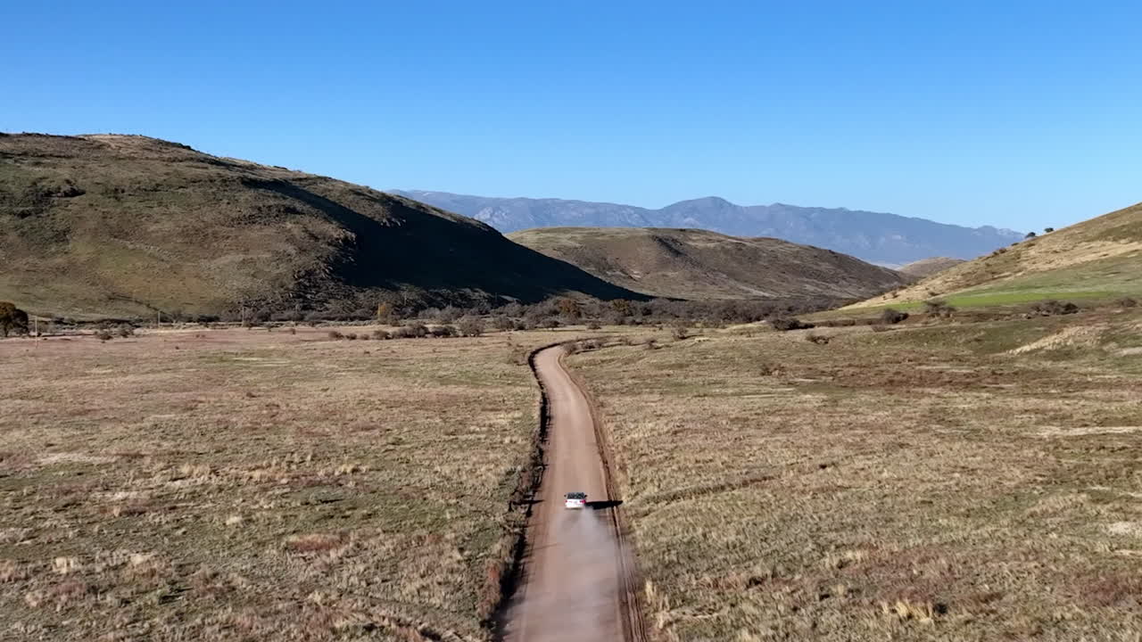 애리조나 주 윌 ⁇ 스 (willcox) 의  ⁇ 길에서 운전하는 자동차의 공중 촬영, 배경에는 산이 있는 넓은 드론 촬영