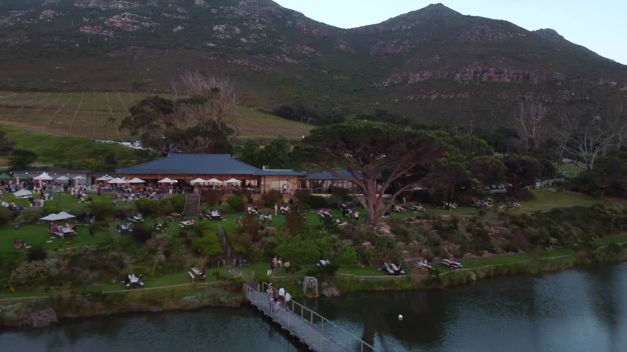 케이프 타운에 있는 포도원의 드론 샷 - 드론이 레스토랑과 외부 지역에서 후진하고 있습니다.