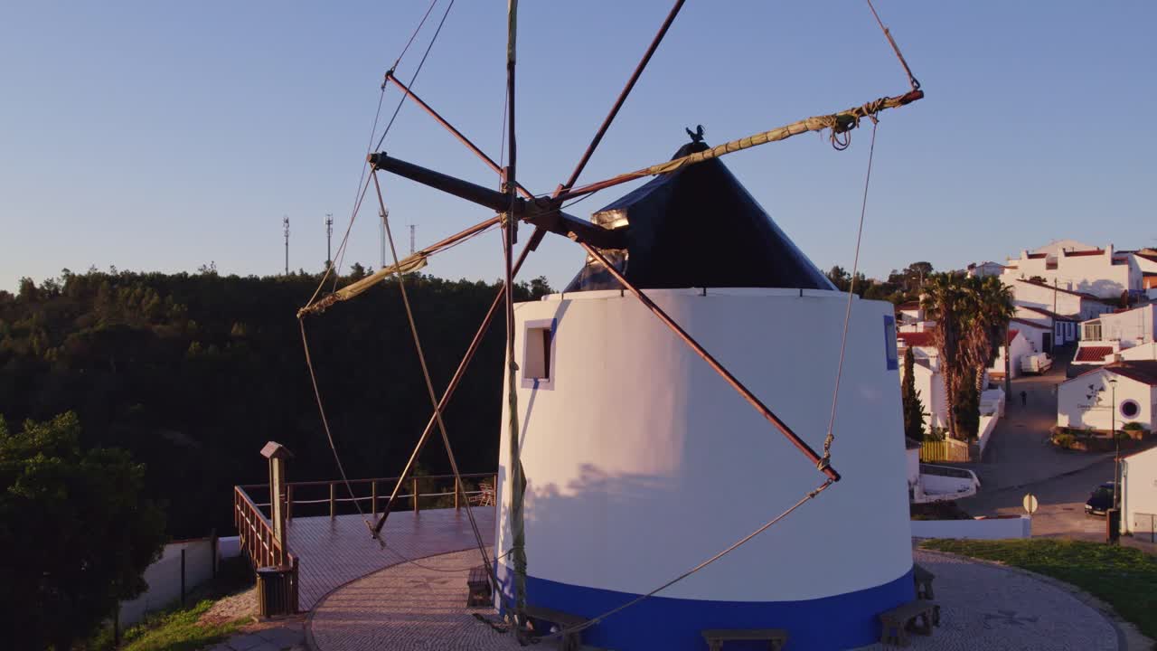 Vista aérea de Odeceixe com moinho de vento, aldeia tradicional, mostrando um cenário histórico calmo em Portugal com grande detalhe