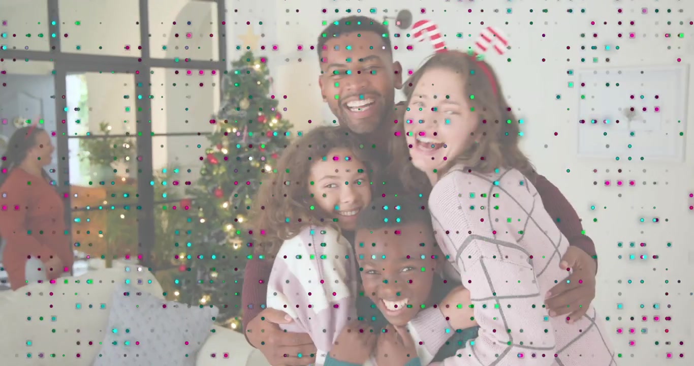 Familie samles nær spejl, mens juletræslys gløder, krammer børn til julehilsen.